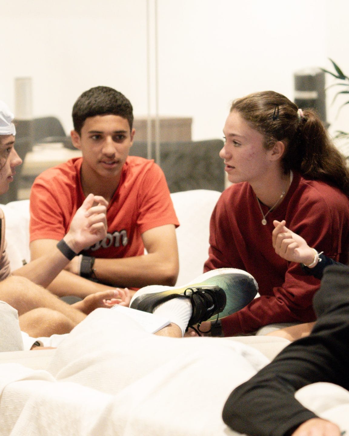 Jugadores y jugadoras jóvenes del TEC conversan sentados en círculo durante una sesión de grupo